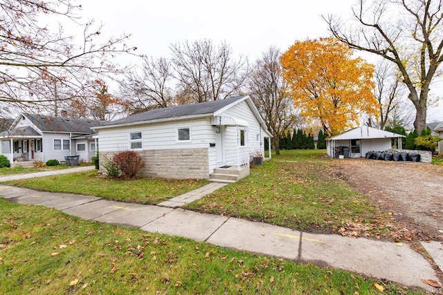 706 N Main St, Nappanee, IN 46550 - view of side of home featuring a yard, stone siding, and driveway