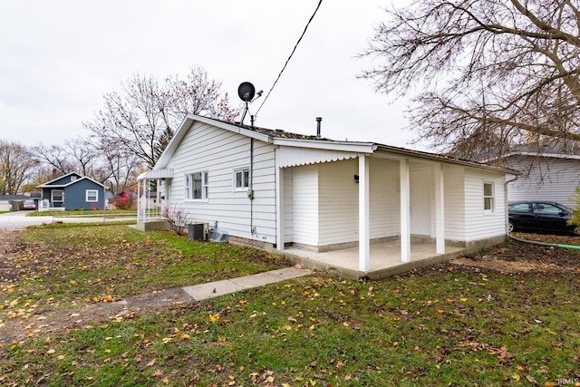 view of home's exterior with a lawn and central AC