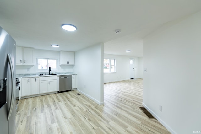 kitchen with light hardwood / wood-style flooring, white cabinets, stainless steel appliances, and sink