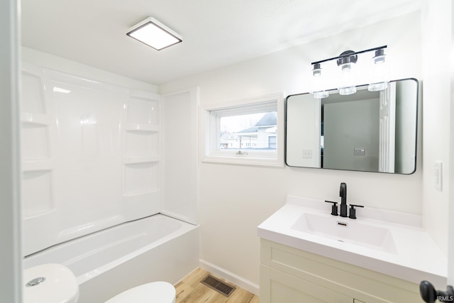 full bathroom with wood-type flooring, vanity, bathing tub / shower combination, and toilet