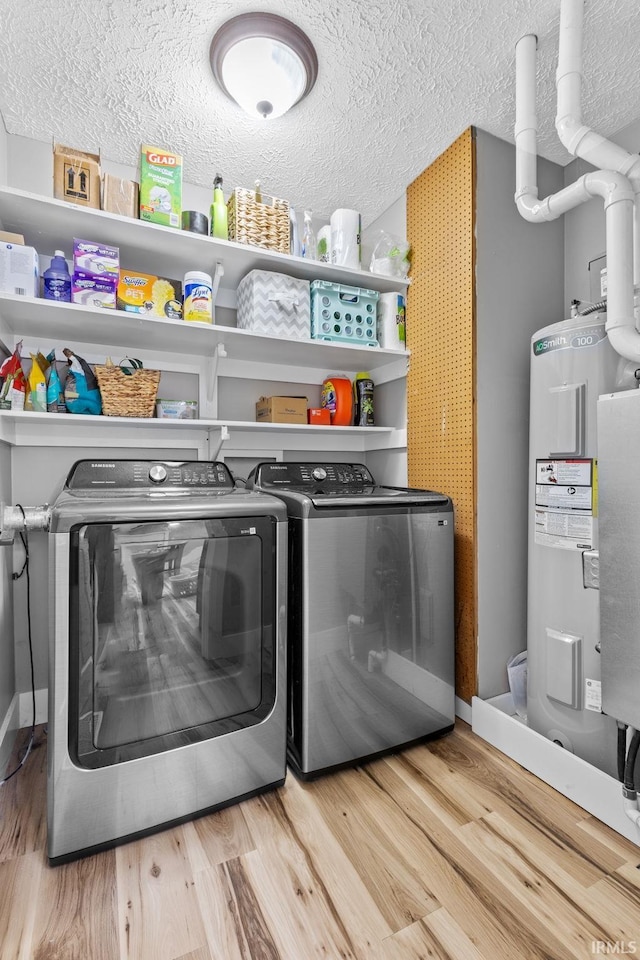 laundry room featuring hardwood / wood-style flooring, separate washer and dryer, a textured ceiling, and water heater