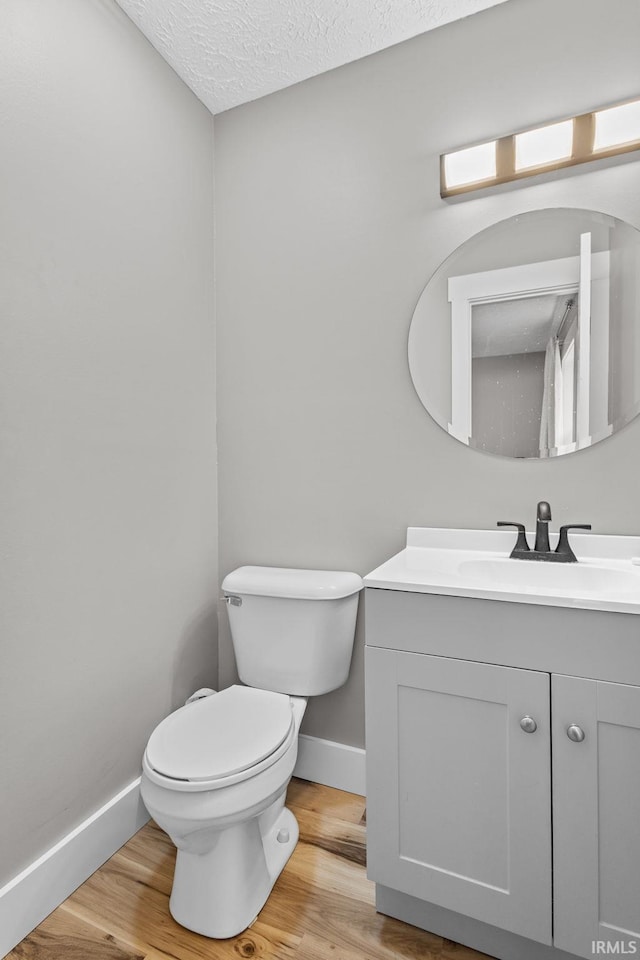 bathroom with vanity, hardwood / wood-style floors, a textured ceiling, and toilet