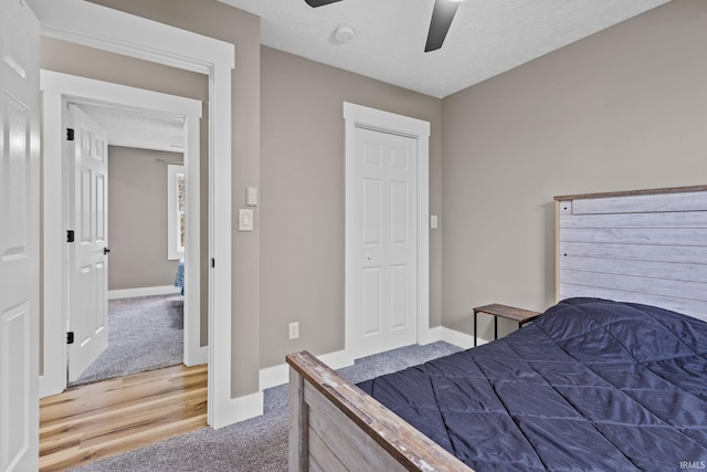 bedroom with hardwood / wood-style floors, a textured ceiling, and ceiling fan