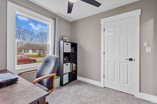 carpeted office featuring a textured ceiling and ceiling fan