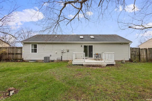 back of property featuring a lawn, a wooden deck, and central AC