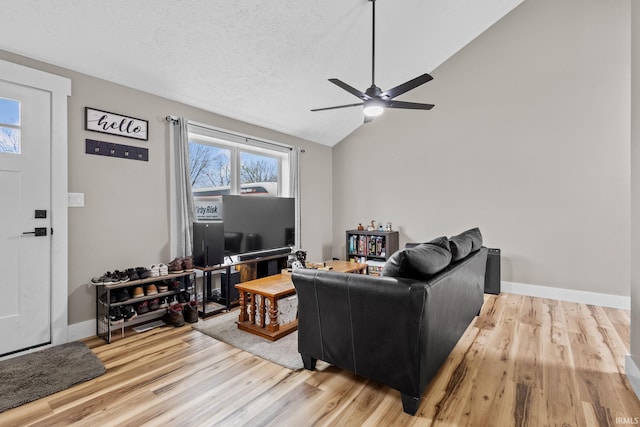 living room featuring a textured ceiling, ceiling fan, lofted ceiling, and light wood-type flooring