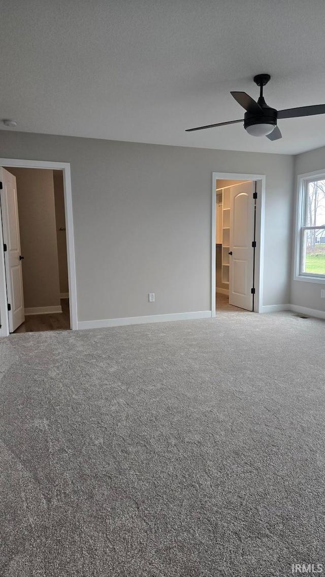 empty room with carpet, ceiling fan, and a textured ceiling