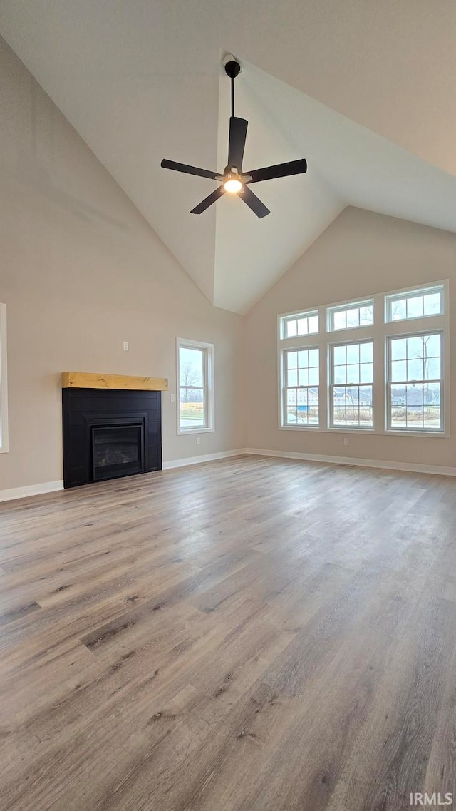 unfurnished living room featuring lofted ceiling, ceiling fan, and a healthy amount of sunlight