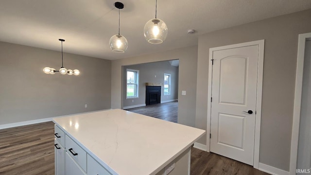 kitchen featuring dark hardwood / wood-style floors, white cabinetry, hanging light fixtures, and a kitchen island