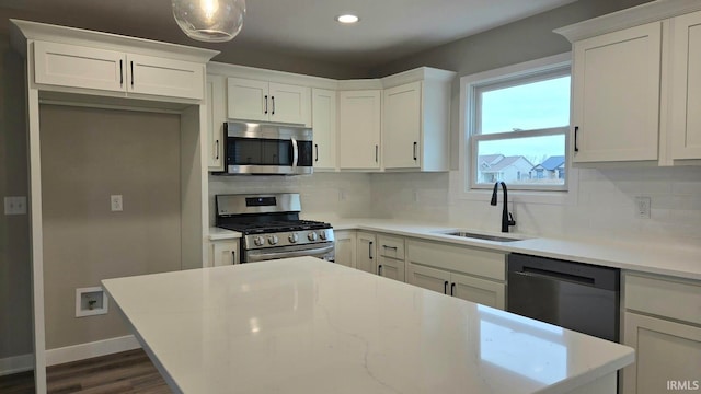 kitchen featuring white cabinets, appliances with stainless steel finishes, tasteful backsplash, and sink