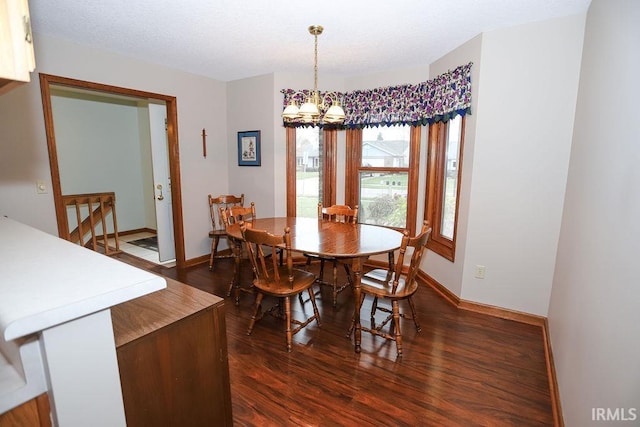 dining area with dark hardwood / wood-style flooring and a chandelier