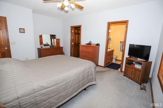 carpeted bedroom featuring ensuite bathroom and ceiling fan