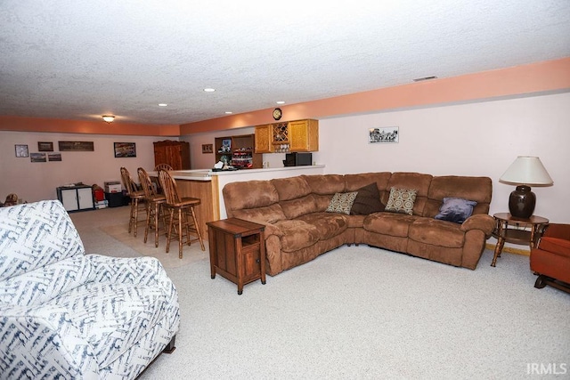 carpeted living room with a textured ceiling and bar