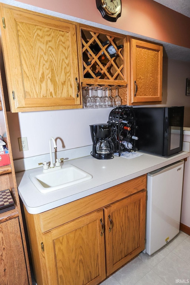 kitchen with light tile patterned floors, white dishwasher, and sink