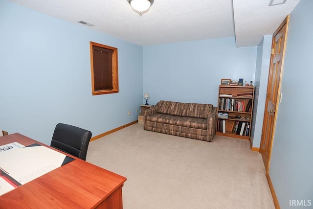 carpeted office featuring a textured ceiling