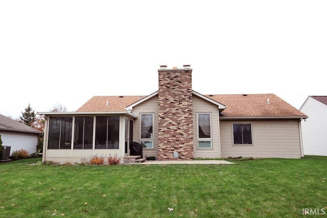 rear view of house featuring a sunroom and a yard