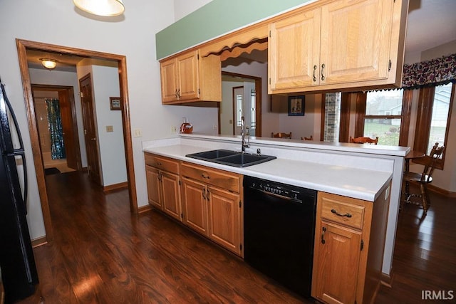 kitchen with kitchen peninsula, dark hardwood / wood-style flooring, sink, and black appliances