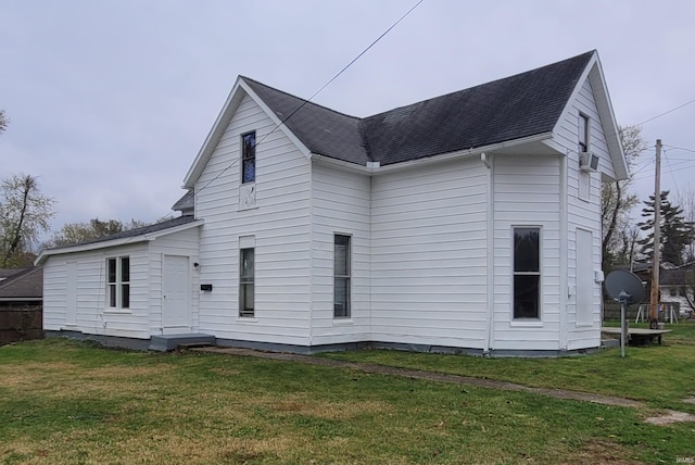 rear view of property featuring a lawn