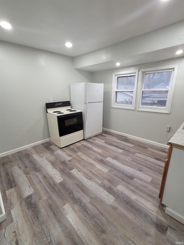 kitchen with white appliances and light hardwood / wood-style floors