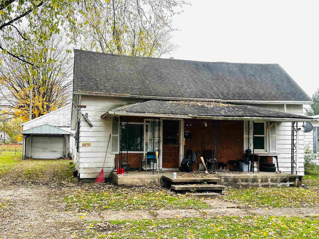 view of front facade featuring an outdoor structure, a porch, and a garage