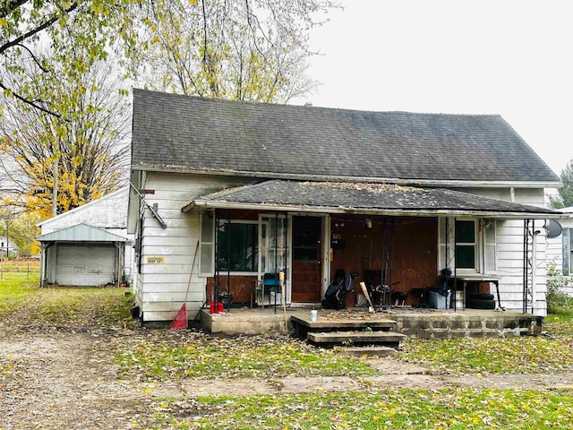 view of front facade featuring an outdoor structure, a porch, and a garage