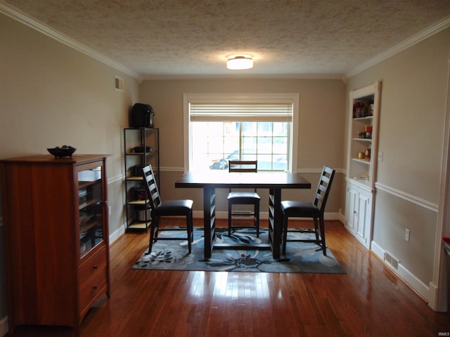 dining area featuring a textured ceiling, wood-type flooring, and crown molding