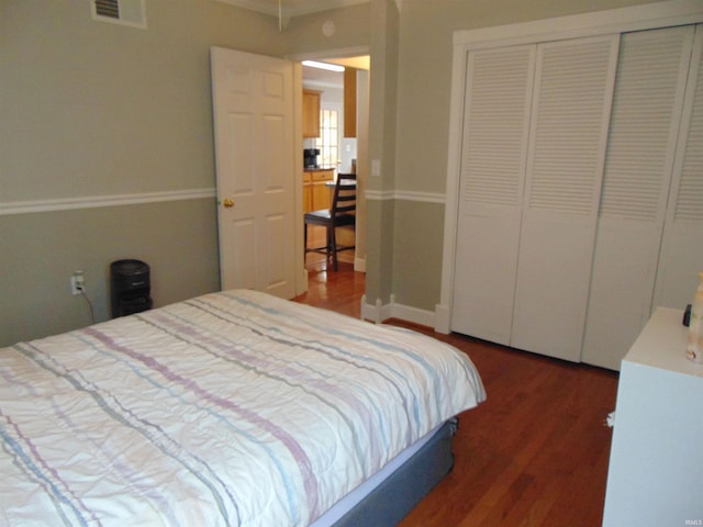 bedroom with dark wood-type flooring and a closet