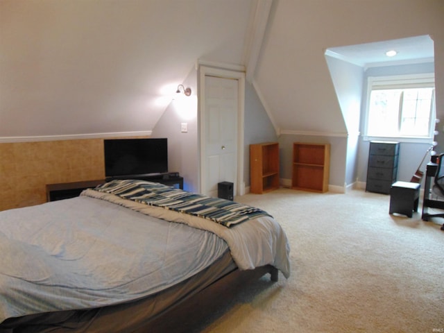 carpeted bedroom with vaulted ceiling and ornamental molding