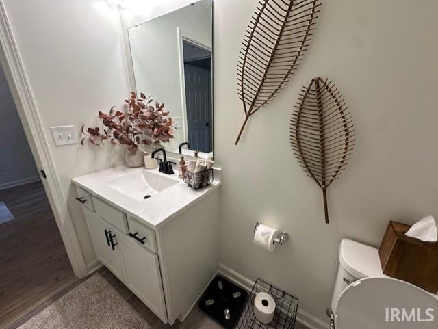 bathroom featuring hardwood / wood-style flooring, vanity, and toilet