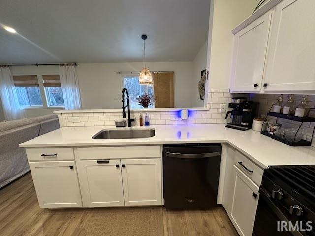 kitchen featuring kitchen peninsula, black dishwasher, a wealth of natural light, and sink