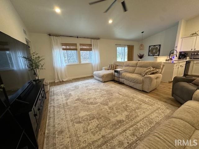 living room featuring light hardwood / wood-style flooring, ceiling fan, lofted ceiling, and sink