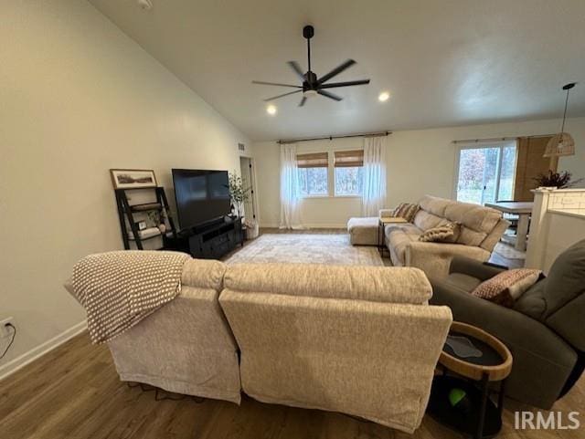 living room with ceiling fan, a healthy amount of sunlight, wood-type flooring, and vaulted ceiling