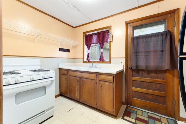 kitchen with crown molding, sink, and white range with gas cooktop