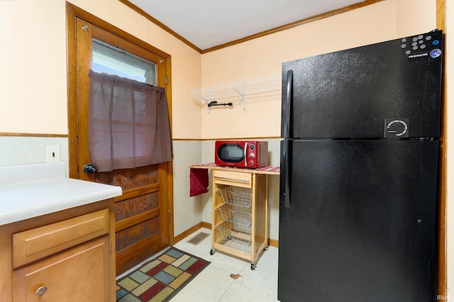 kitchen featuring black fridge and ornamental molding