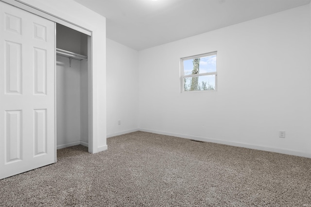 unfurnished bedroom featuring carpet flooring and a closet