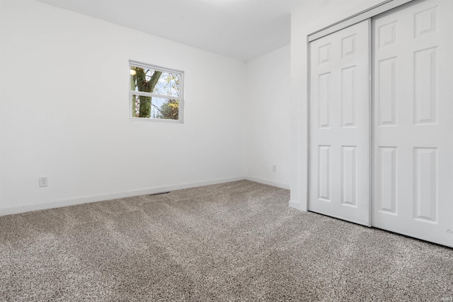 unfurnished bedroom featuring carpet flooring and a closet