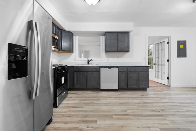 kitchen with electric panel, stainless steel appliances, light hardwood / wood-style flooring, and sink