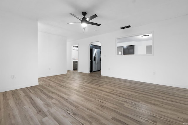 unfurnished living room featuring ceiling fan and wood-type flooring