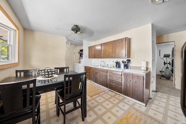 kitchen with washer / clothes dryer, ceiling fan, and sink