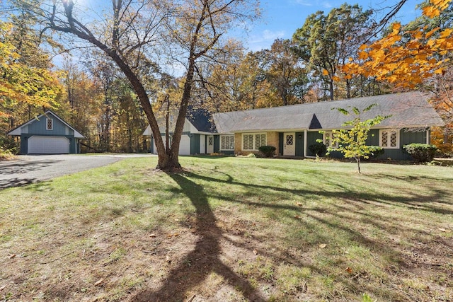 ranch-style house featuring an outbuilding, a front lawn, and a garage