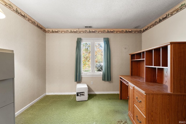 unfurnished office featuring a textured ceiling and carpet floors