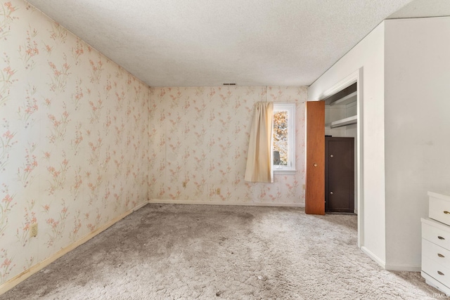 empty room with carpet and a textured ceiling