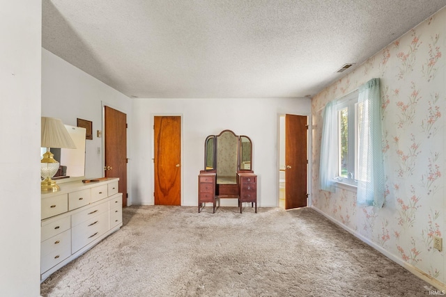 bedroom featuring a textured ceiling and light carpet