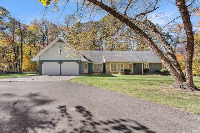 single story home featuring a garage and a front yard