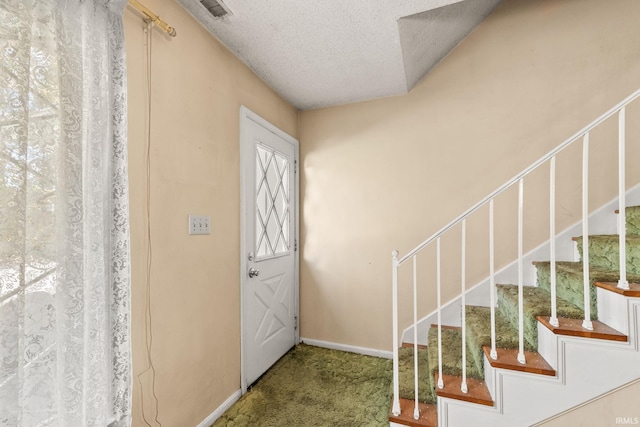 foyer with carpet flooring and a textured ceiling