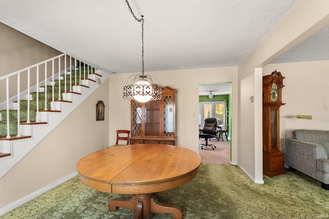 carpeted dining space with a textured ceiling