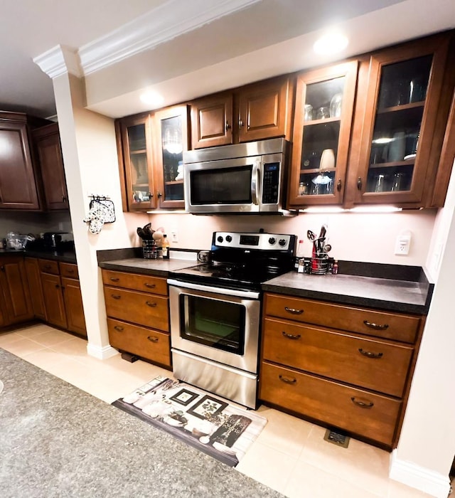 kitchen featuring crown molding, light tile patterned floors, and appliances with stainless steel finishes