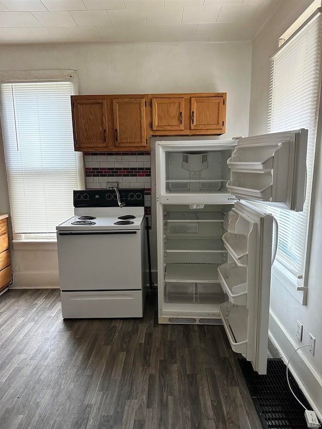 kitchen featuring white electric range, dark wood-type flooring, fridge, and tasteful backsplash