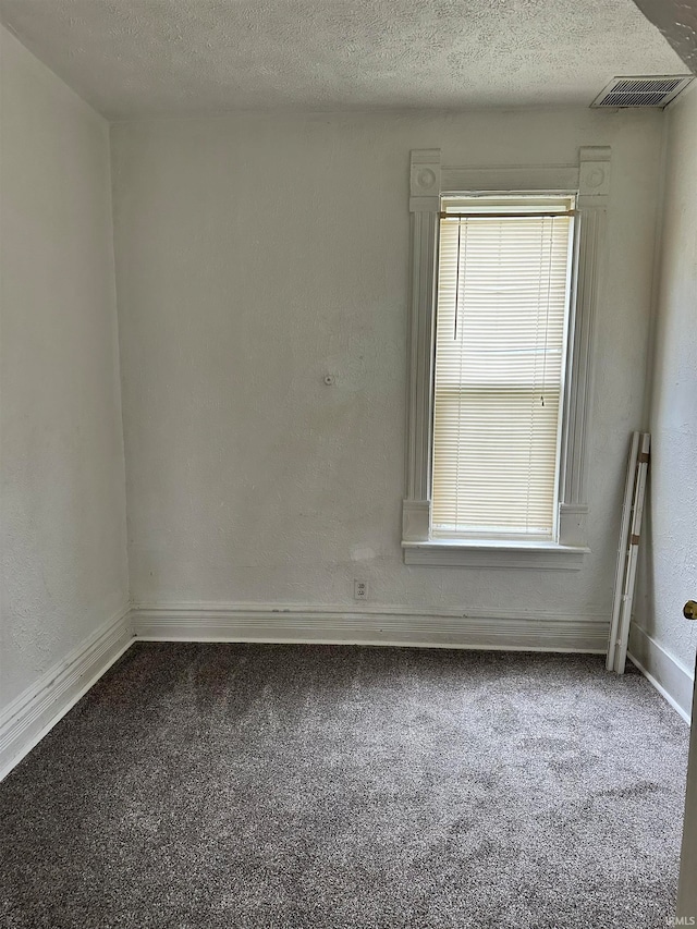 carpeted spare room featuring a textured ceiling