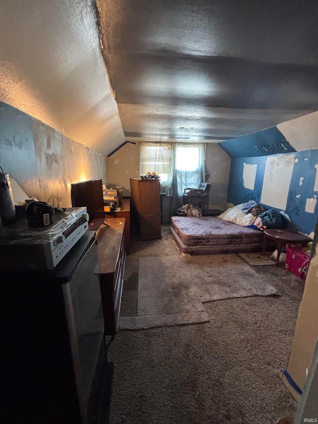 carpeted bedroom featuring a textured ceiling and vaulted ceiling